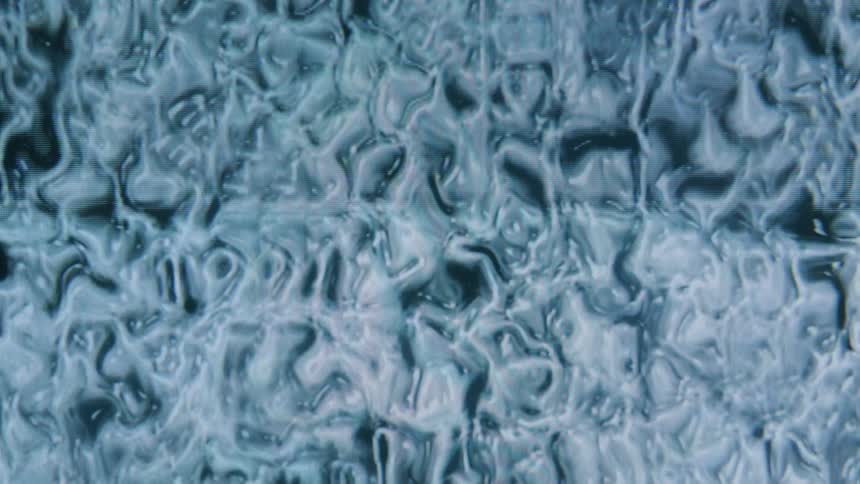 Extreme close up of a dense liquid in blue and white color in abstract motion