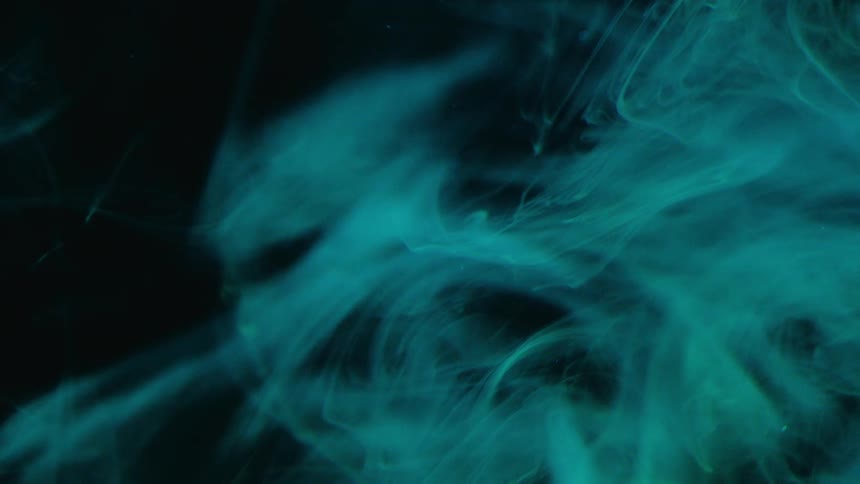 Wisps of blue smoke swirl against a dark background