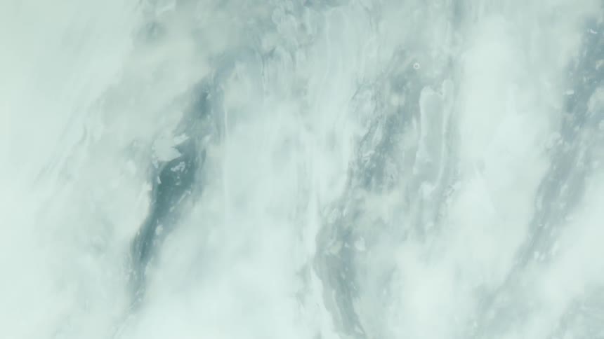 Swirling patterns of blue and white paint create an abstract marbled design