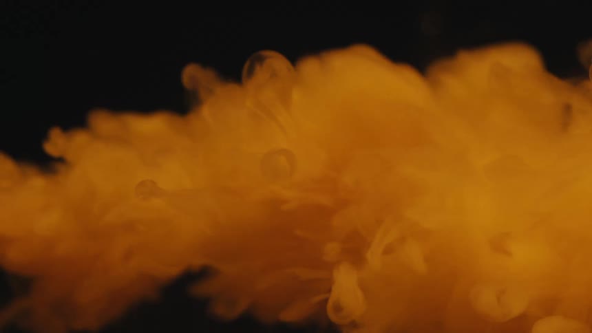 Yellow smoke flows through the air rapidly before slowing and floating