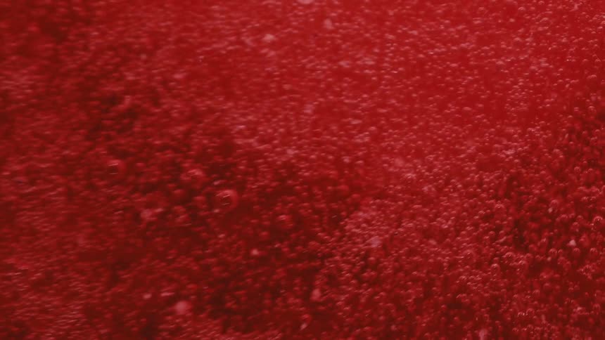 Extreme close up of abstract carbonated red liquid