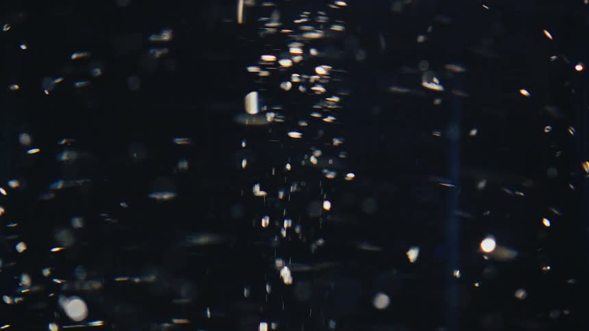 Close up of liquid with abstract confetti in rotating motion