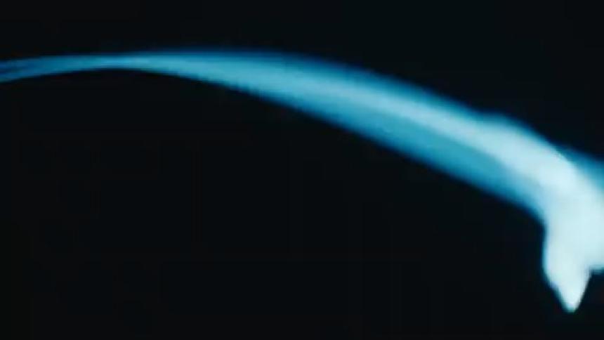 Blue light in rotating motion against a black background