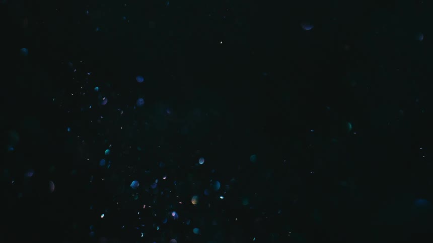 A celestial dance of shimmering blue specks illuminates the inky blackness evoking a sense of wonder and mystery