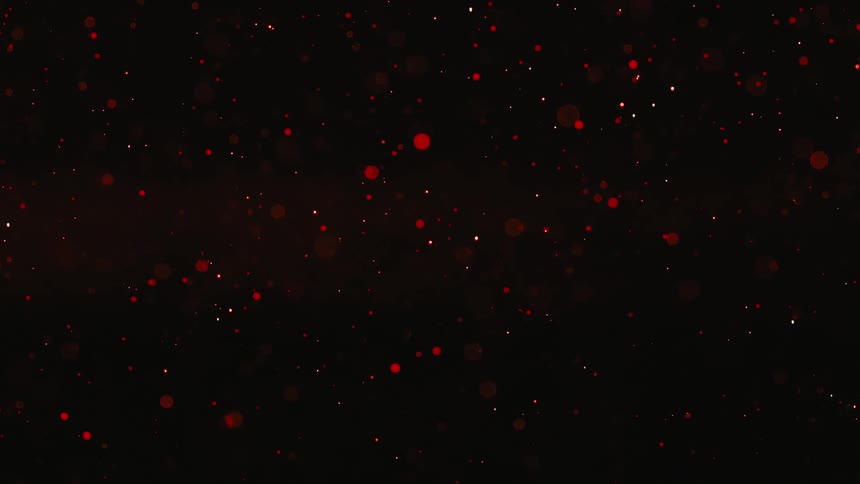 A dark liquid is sprinkled with small red sparkly dots