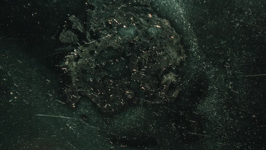 Liquid flowing into a green shiny abstract texture
