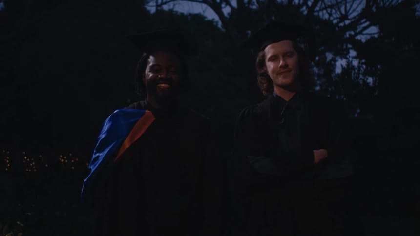 Friends pose for pictures in their academic clothing