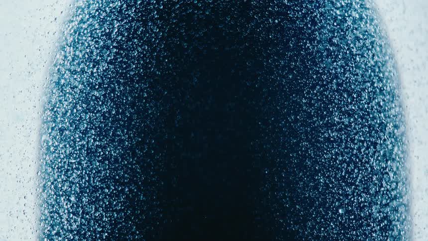 Water droplets floating against a dark surface