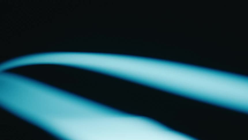 Two curved glowing blue lines spinning against a dark background