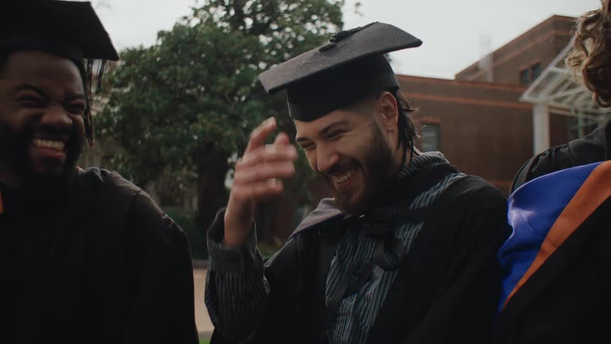 Happy friends in graduation outfits