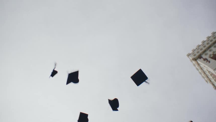 Collge graduate throwing thier caps in air in celebration