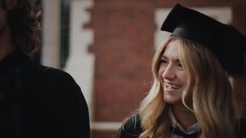 Portrait of a happy blonde woman with a graduation gown