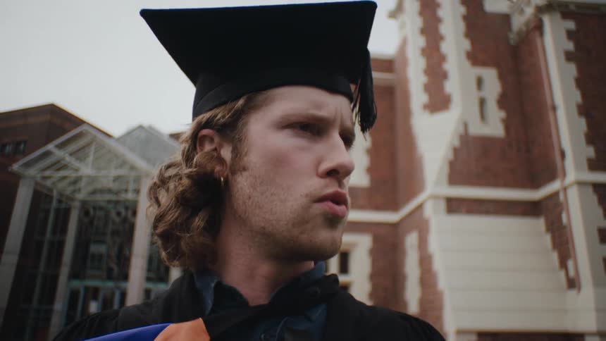 Side portrait of a man wearing a graduation gown