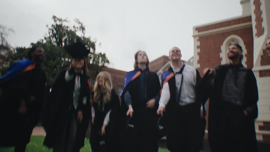 Group of students throwing graduation caps into the air