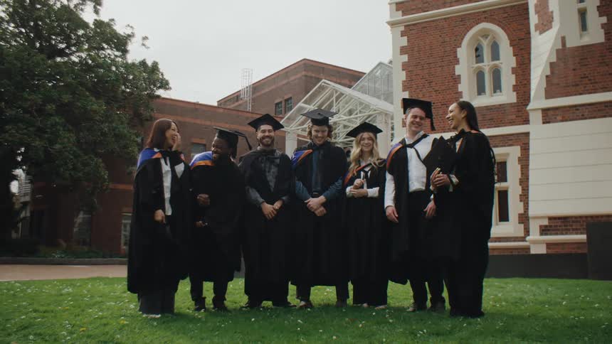 Group of happy students in graduation gown outfit