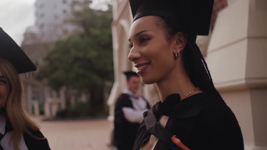 Fellow graduates smile and talk to each other