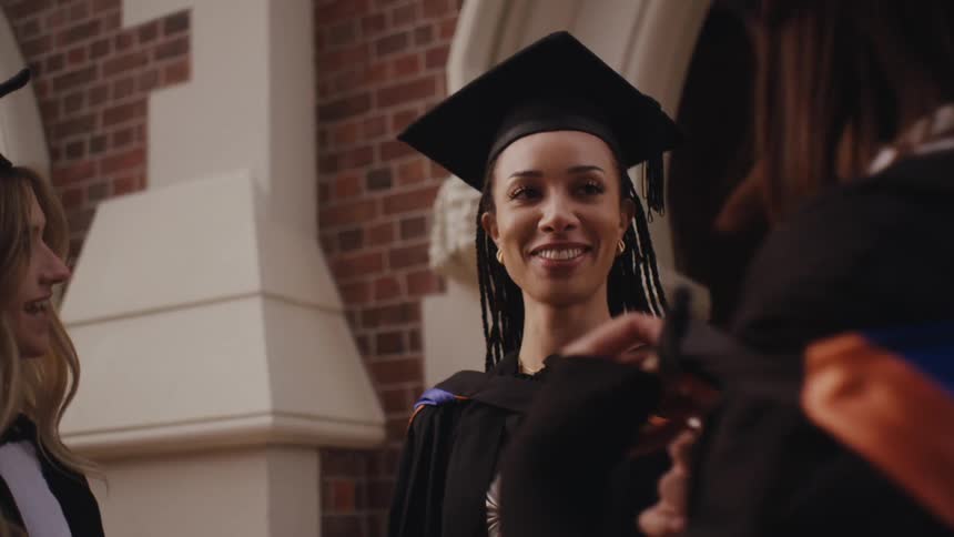 Friends in graduation gowns talking to each other