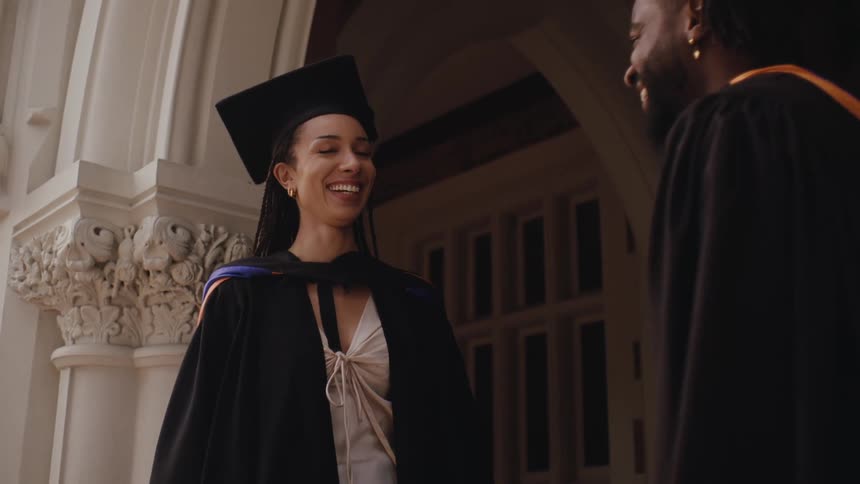 Man and woman talking with graduation gown