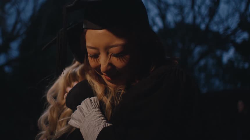 A clip of graduates sharing a hug