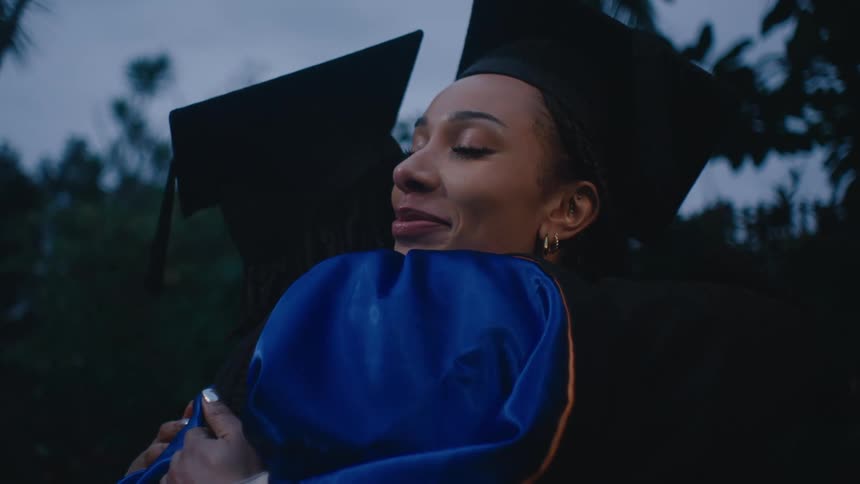 A clip of graduating students sharing a hug