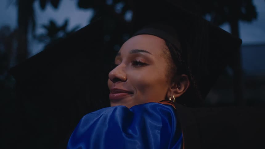 Man and woman hugging both in graduation attire