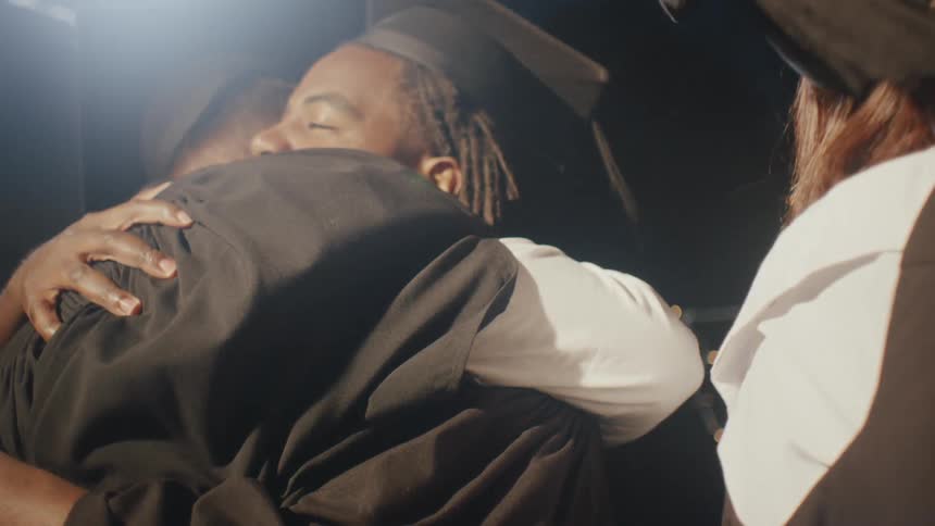 Graduates celebrate and hug at night