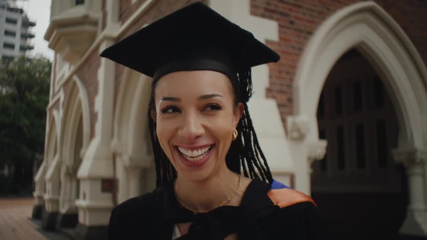 Woman in graduation gown smiling