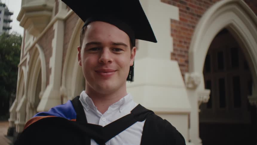 Portrait of a student with happy facial expression posing with graduation gown