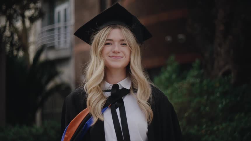 Portrait of a blonde college student with graduation gown