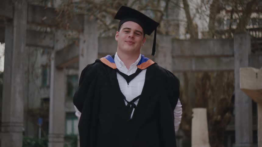 Happy college man with graduation gown