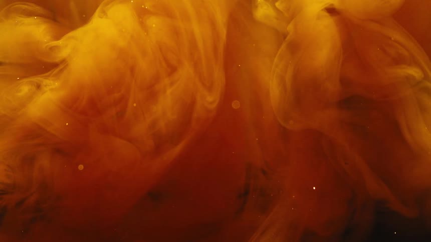An orange substance rapidly expands when introduced to a clear medium