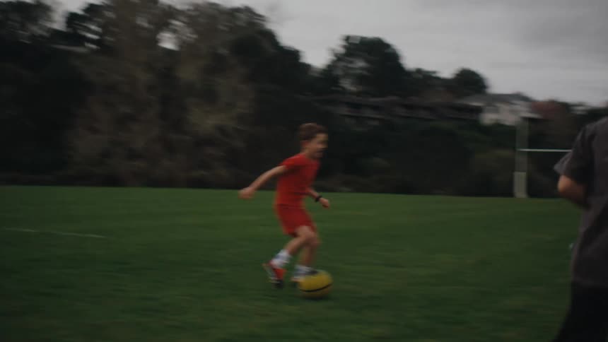 Children playing soccer on a green field