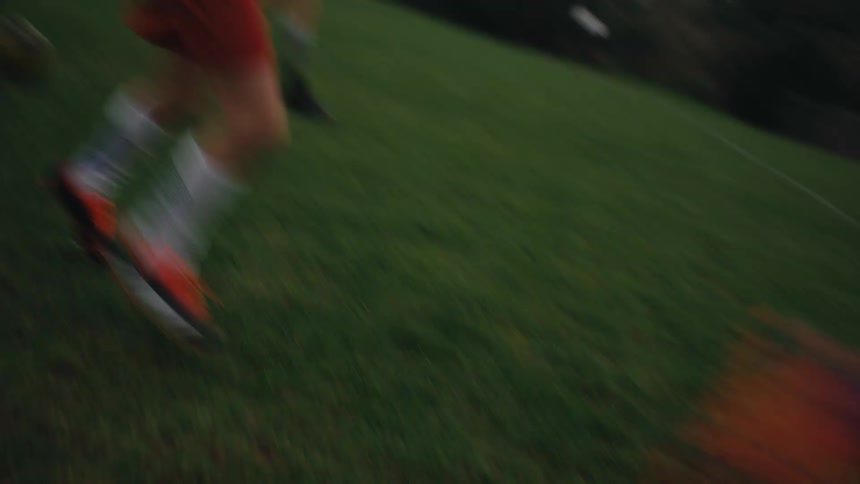 A team of teen girls and boys playing soccer on a green field