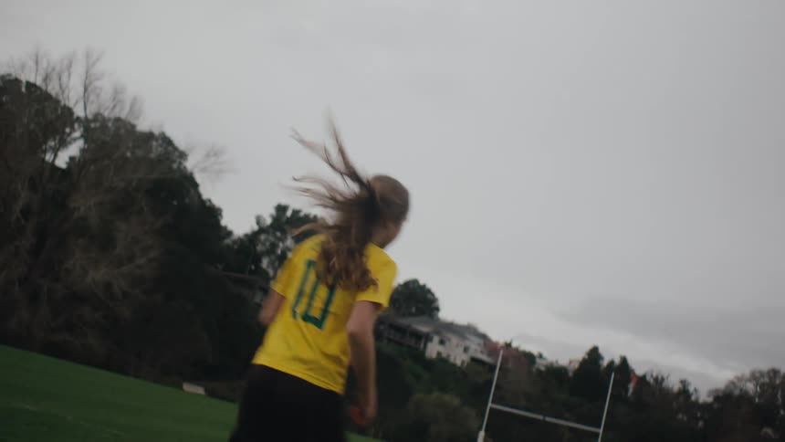 Girl playing soccer and kicking the ball towards the goal