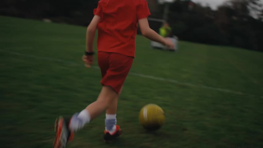 Boys playing soccer on a grass field