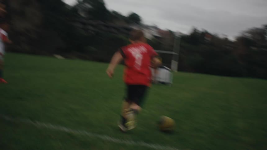 Boys playing soccer on a grass field