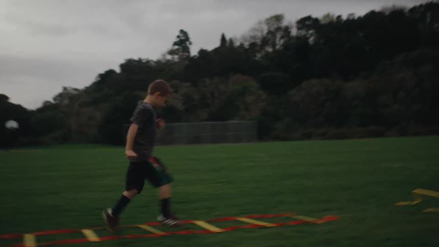 Boy doing educational warmup exercise on grass