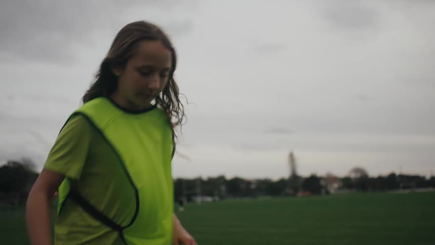 Girl on a soccer field jumping doing educational exercises