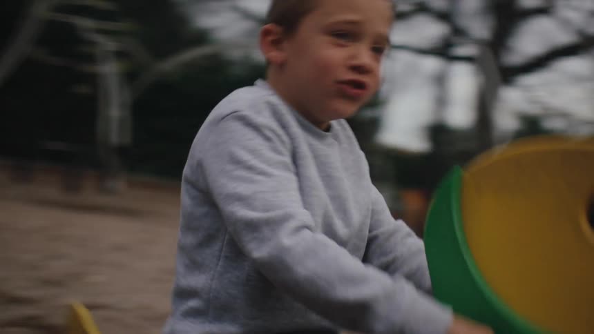 A child is swinging on the playground ride
