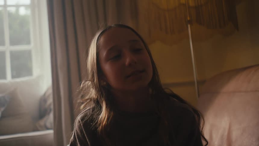 A girl sitting on a couch in the living room talking