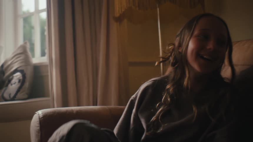 Two little girls sitting in the living room talking to each other