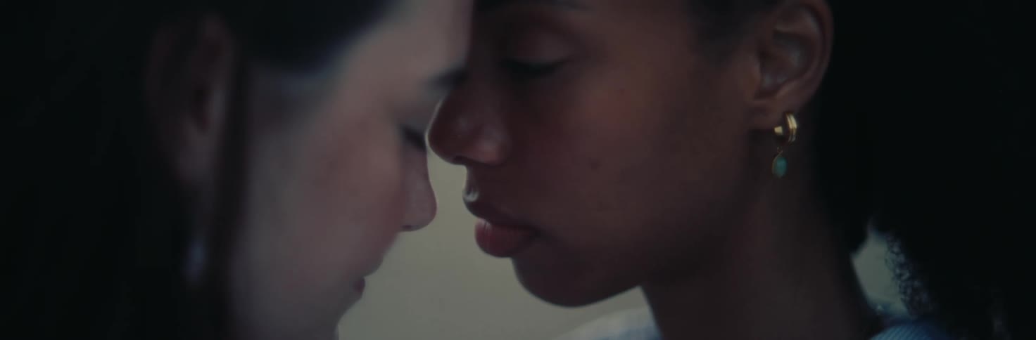 Two women with their eyes closed their foreheads touching each other