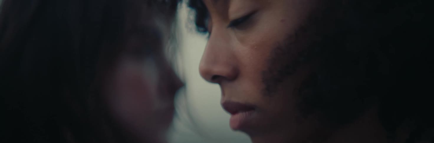 Side portrait of the faces of two women standing close together
