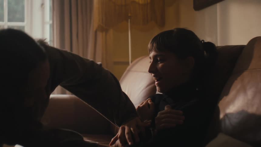Two little girls playing push and pull while sitting on the couch in the living room