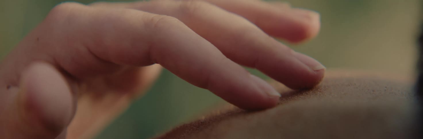 Person runs their finger tips over the skin of another