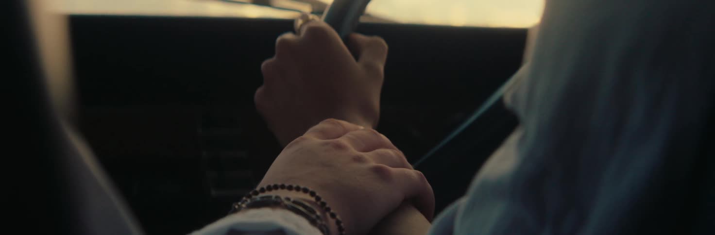 One persons hand placing it on top of another persons hand