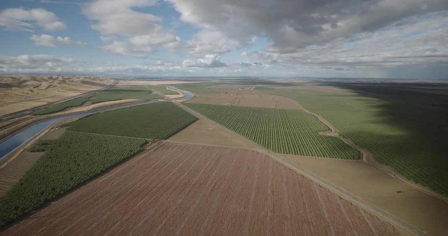 Aerial panorama of an agricultural field on the edge of a canal