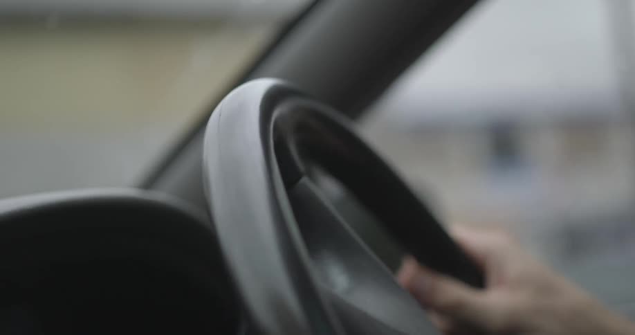 A man turns a car steering wheel