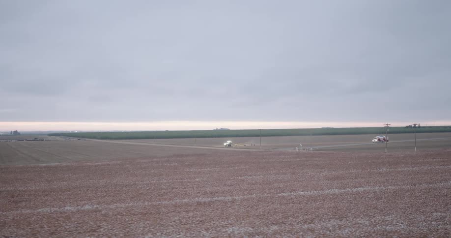 Vehicles drive across the farm