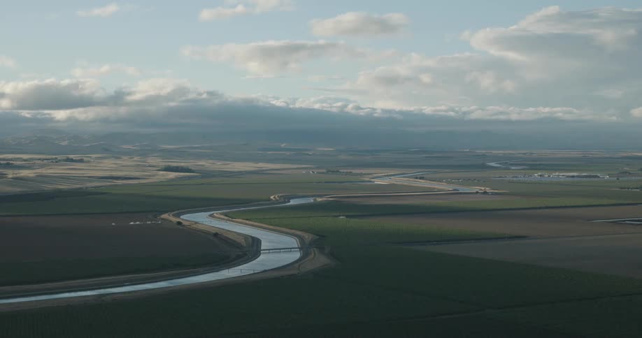 Aerial view of river winding through landscape on cloudy day